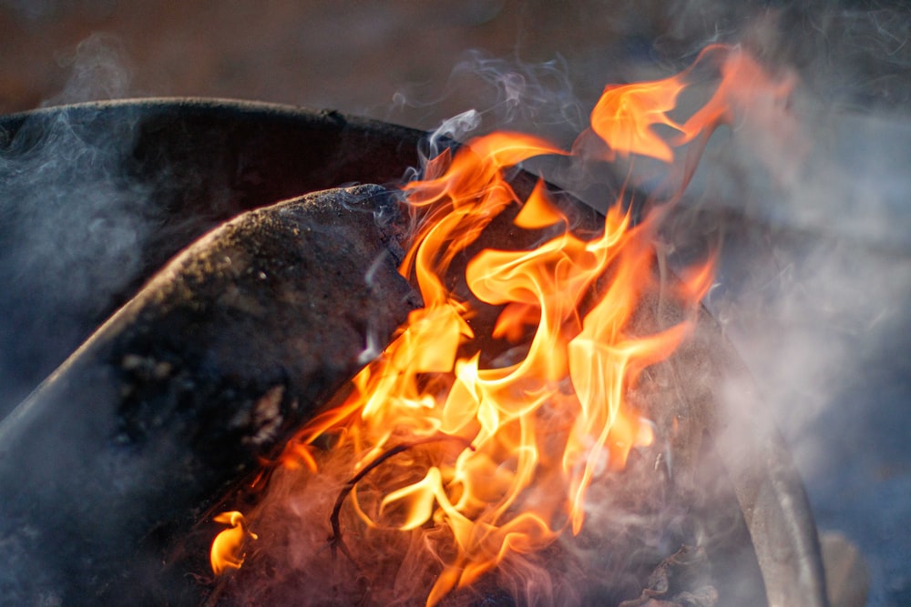 a close up of a grill with flames and smoke coming out of it