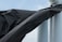 A large black tarp or plastic sheet is wrapped around a structure composed of two white cylindrical pipes. The sky is visible in the background, with light cloud coverage.