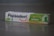 A box of Pepsodent toothpaste with the label 'Complete 8 Herbal' featuring a green and white design. The package includes images of a lime and mint leaves, and contains descriptions in Indonesian about its herbal ingredients. The Pepsodent logo is prominently displayed in blue with a red smile underneath.