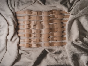 A set of vintage kitchen utensils arranged artfully on a textured fabric background.