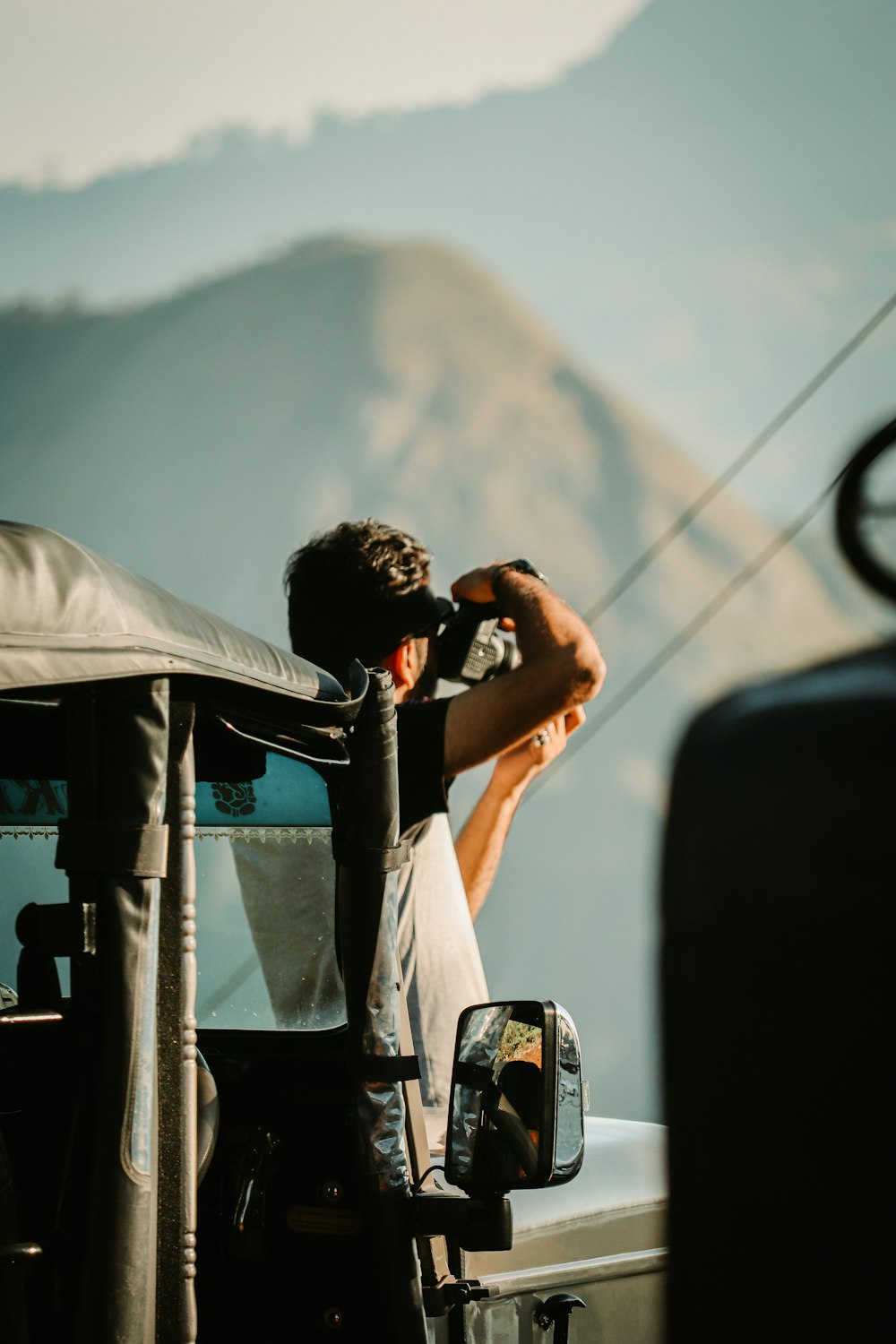 a man sitting in the back of a truck talking on a cell phone