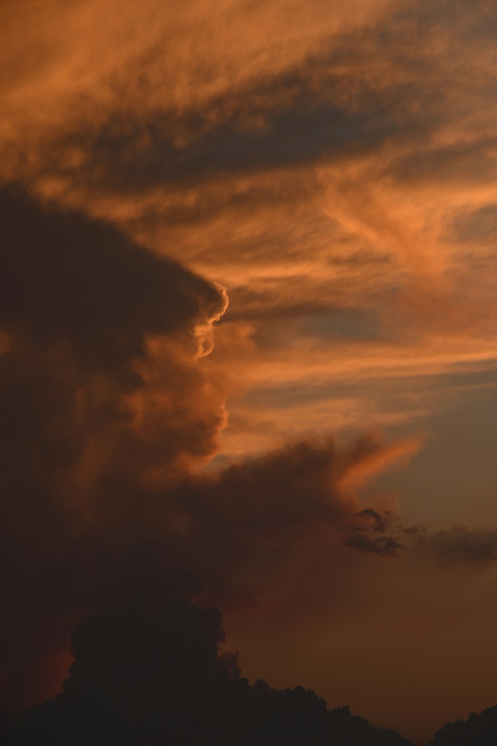 a plane flying in the sky at sunset