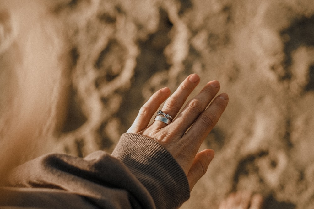 a woman is holding her hand up to the sky