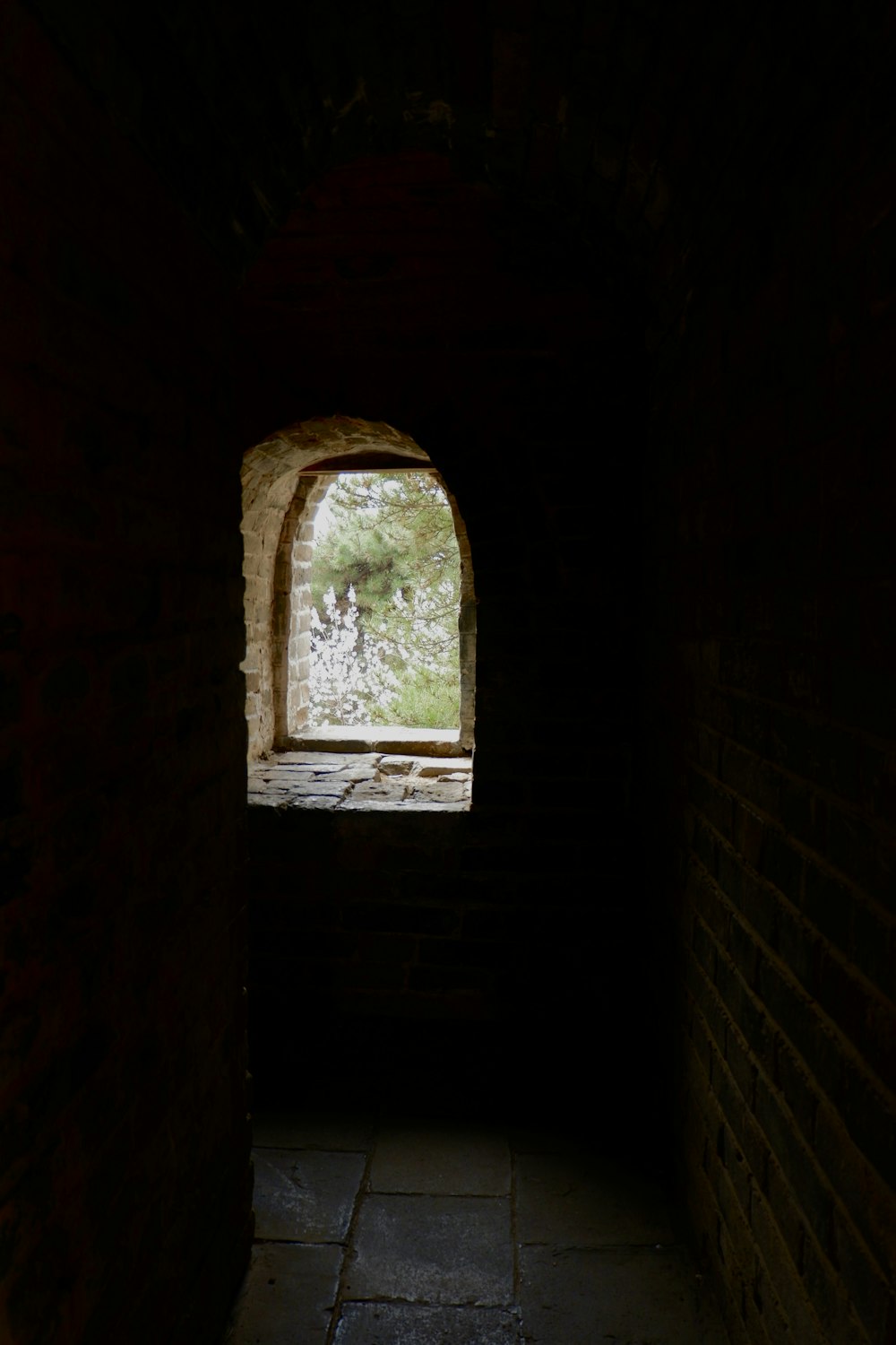 a dark tunnel with a small window in it