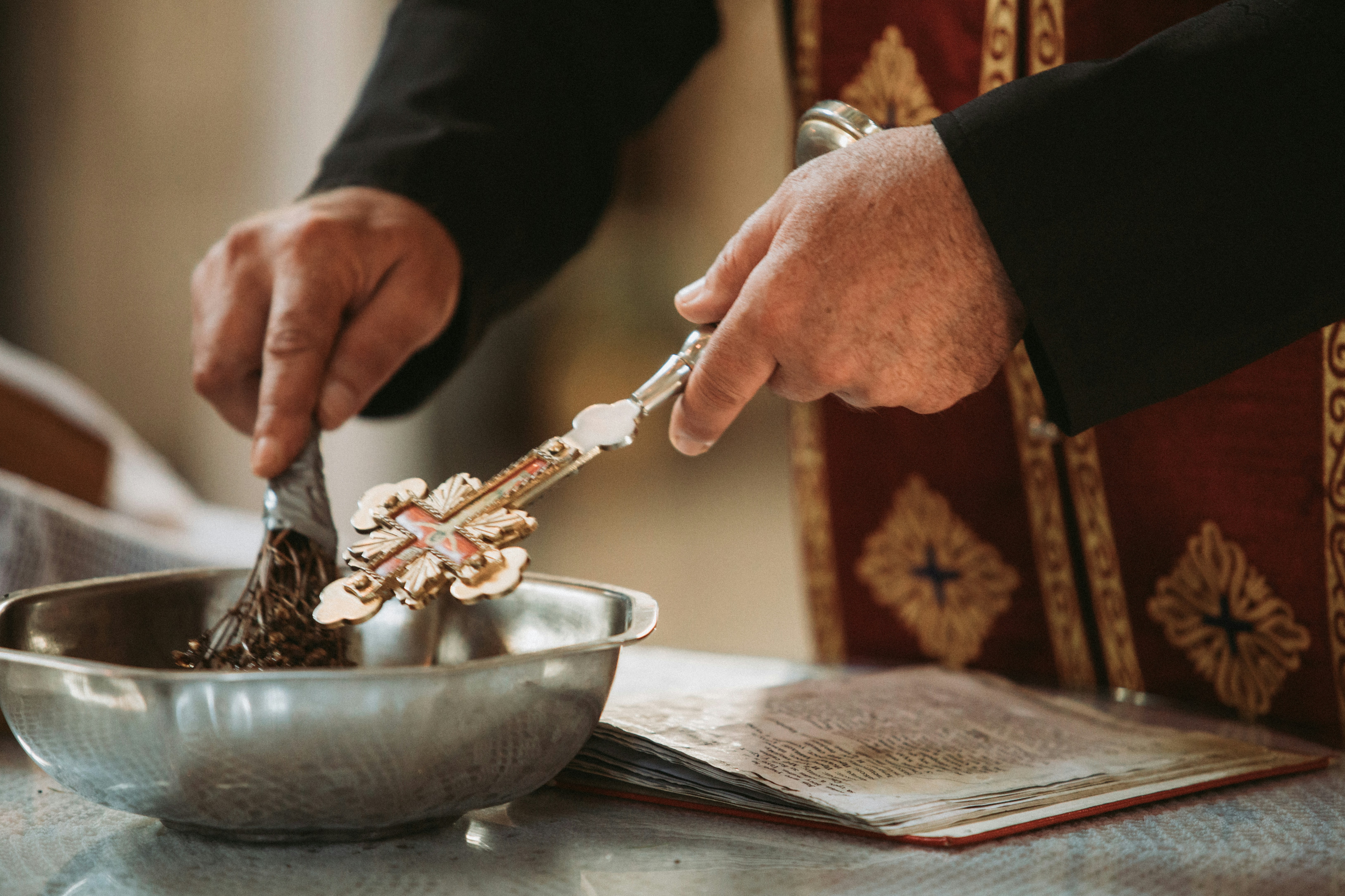 a man in a priest's uniform is spooning chocolate into a bowl