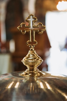 Close-up of a luxurious handcrafted churrugaresco decorative cross with intricate gold and black details.