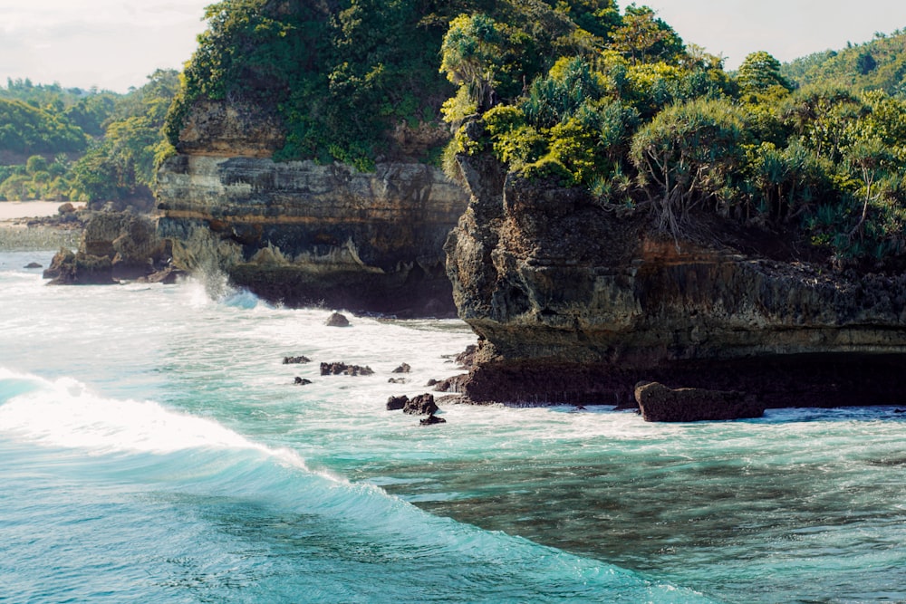 a large body of water next to a rocky cliff