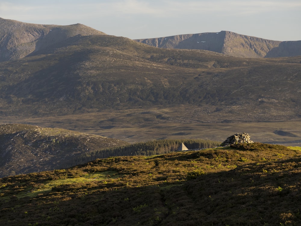 a house on a hill with mountains in the background