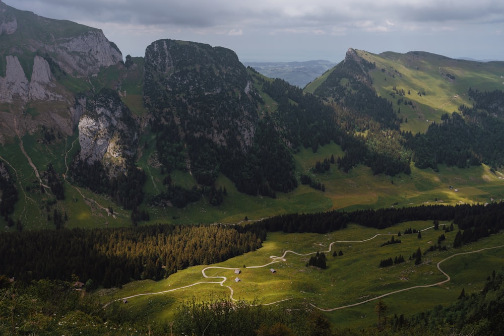 a scenic view of a mountain range with a winding road