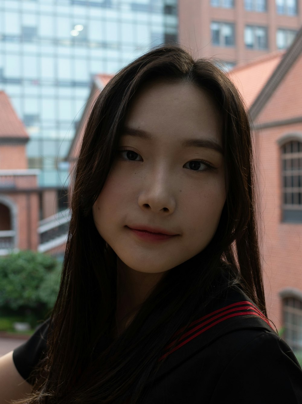 a woman with long hair standing in front of a building