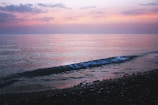 A quiet moment of reflection by the sea at Menton, with gentle waves and a pastel sunset.