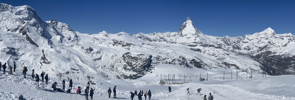 a group of people standing on top of a snow covered slope