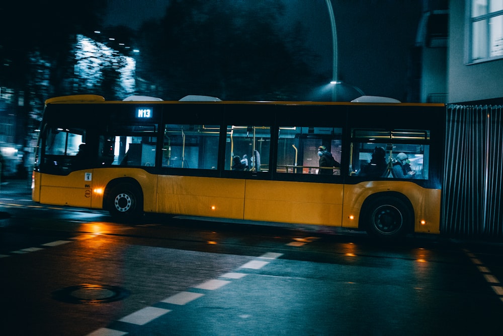 Un bus jaune roulant dans une rue la nuit