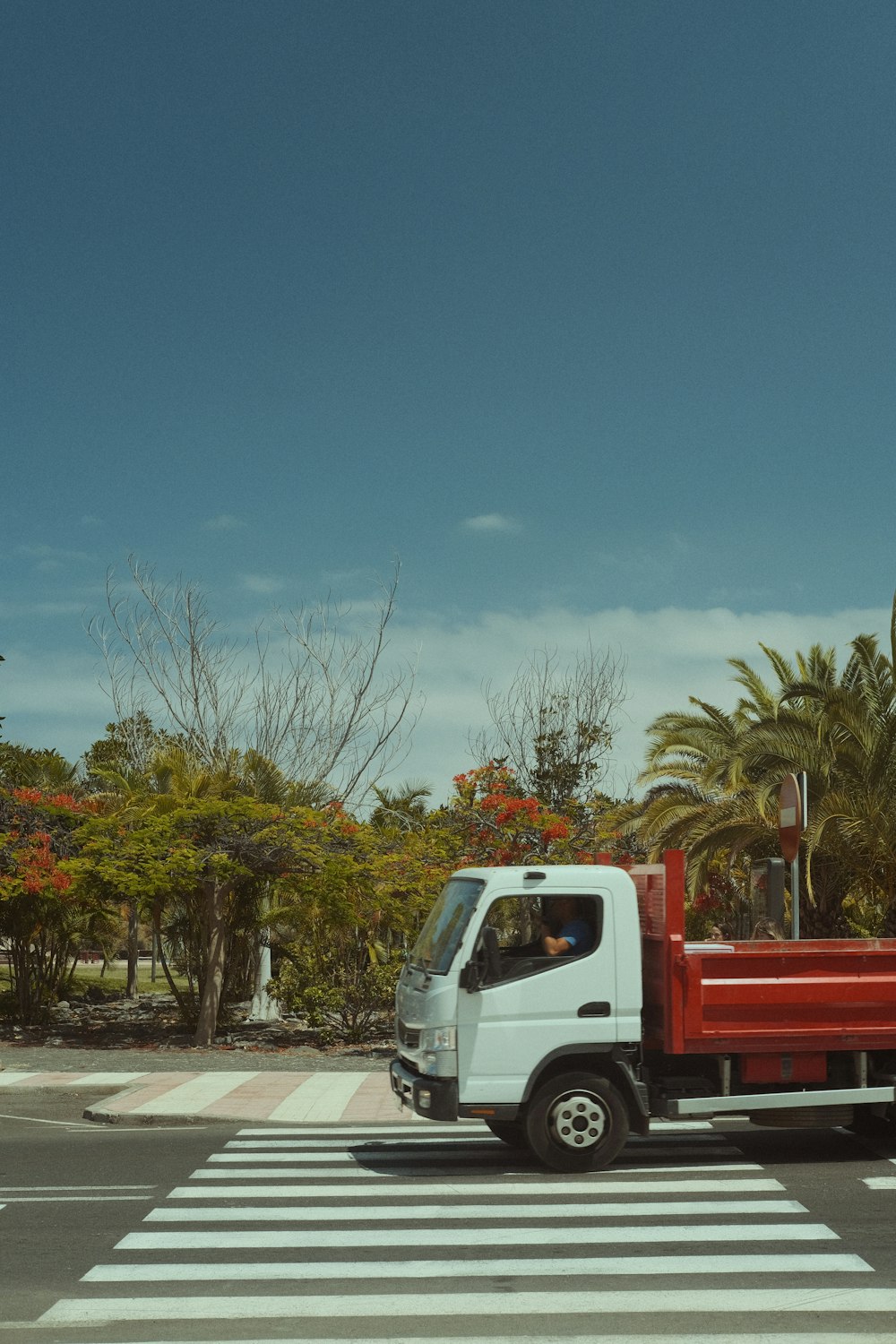 a red and white truck driving down a street