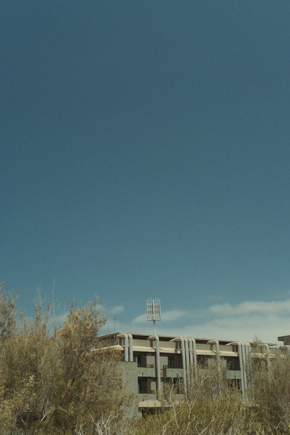 a very tall building sitting in the middle of a field