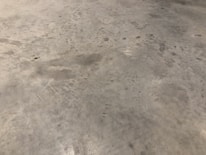 Before and after shots showing a commercial floor transformed by epoxy resurfacing.