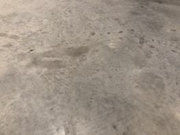 Before and after images of a polished concrete floor in an industrial warehouse.