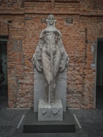 Elegant vintage sculpture carved from marble, standing tall against a minimalist white background.