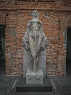 Elegant abstract stone figure with warm earth tones displayed against a minimalist white backdrop.