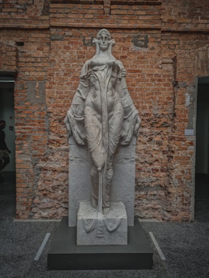 Elegant vintage sculpture carved from marble, standing tall against a minimalist white background.