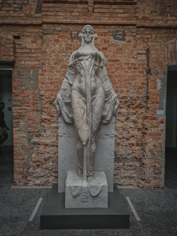 Elegant abstract stone figure with warm earth tones displayed against a minimalist white backdrop.