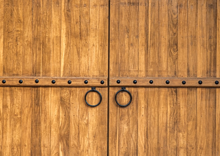 a large wooden gate with metal rings on it