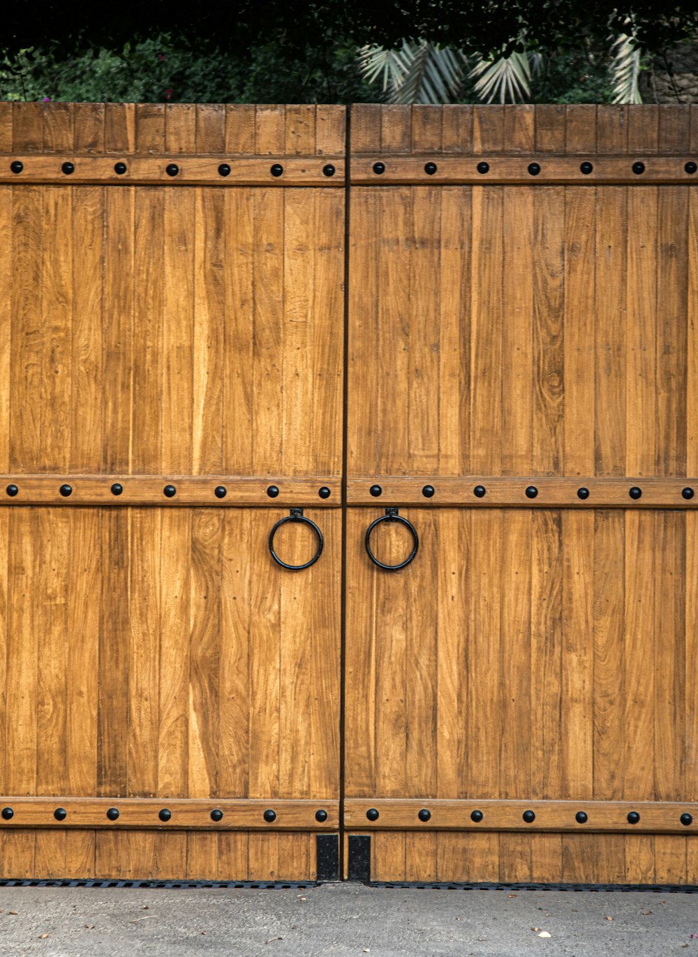 a large wooden gate with metal rings on it