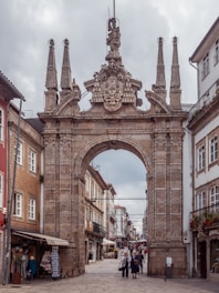 a large stone arch in the middle of a street