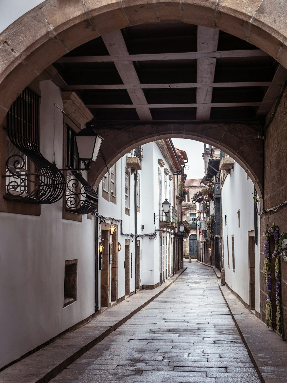 a narrow alley way with white buildings and a stone walkway