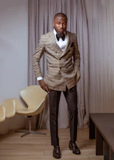 Portrait of Webber Chin in a navy blue suit, standing confidently in a modern office with gold accents.