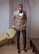 Photo of a confident man in business attire standing in a modern living room.