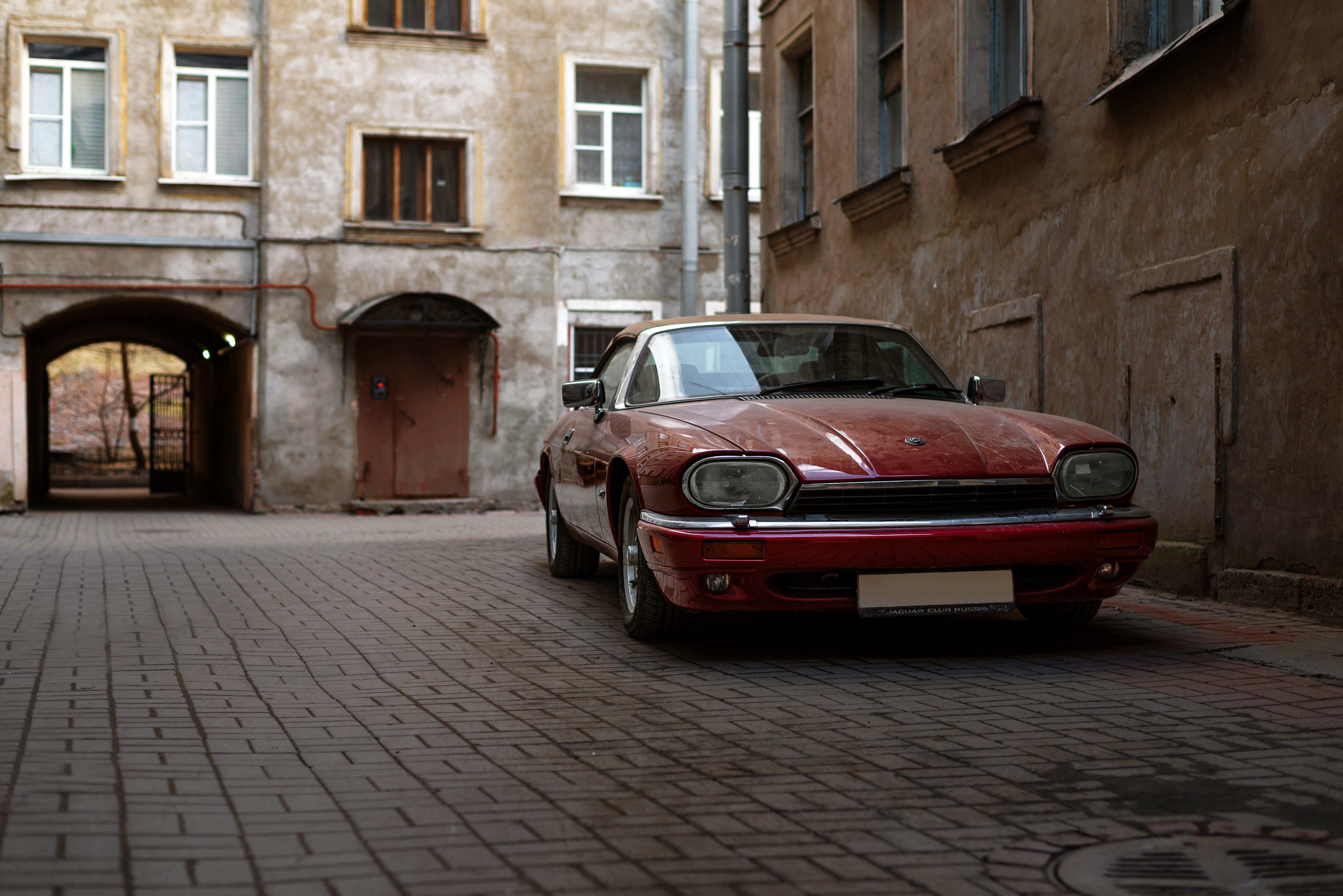 a red car parked on a brick street