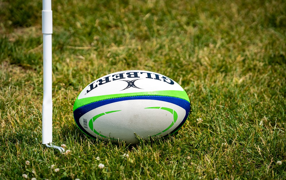 a rugby ball sitting on top of a lush green field