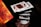 A series of playing cards appear to be floating in mid-air, capturing a dynamic moment possibly from a magic trick or cardistry performance. The cards are fanned out, aligning symmetrically as a hand beneath adds a sense of motion. The focus is sharp on the cards, highlighting their detailed patterns and suits.