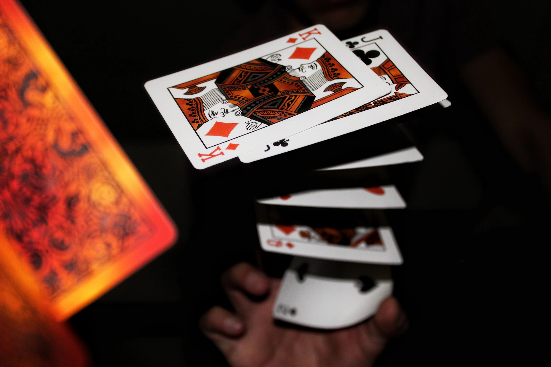 A mysterious magician performing an elegant close-up card trick under soft blue lighting in Bogotá.