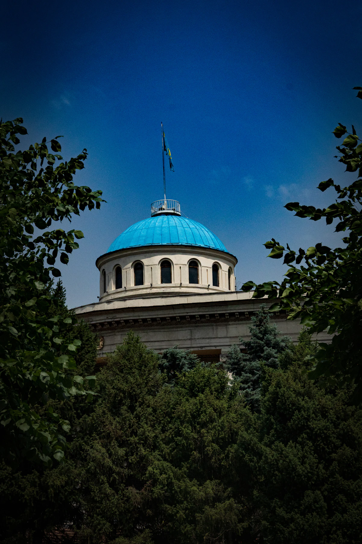 Blue dome of a cathedral surrounded by trees in Almaty