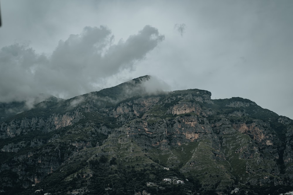 a very tall mountain with some clouds in the sky