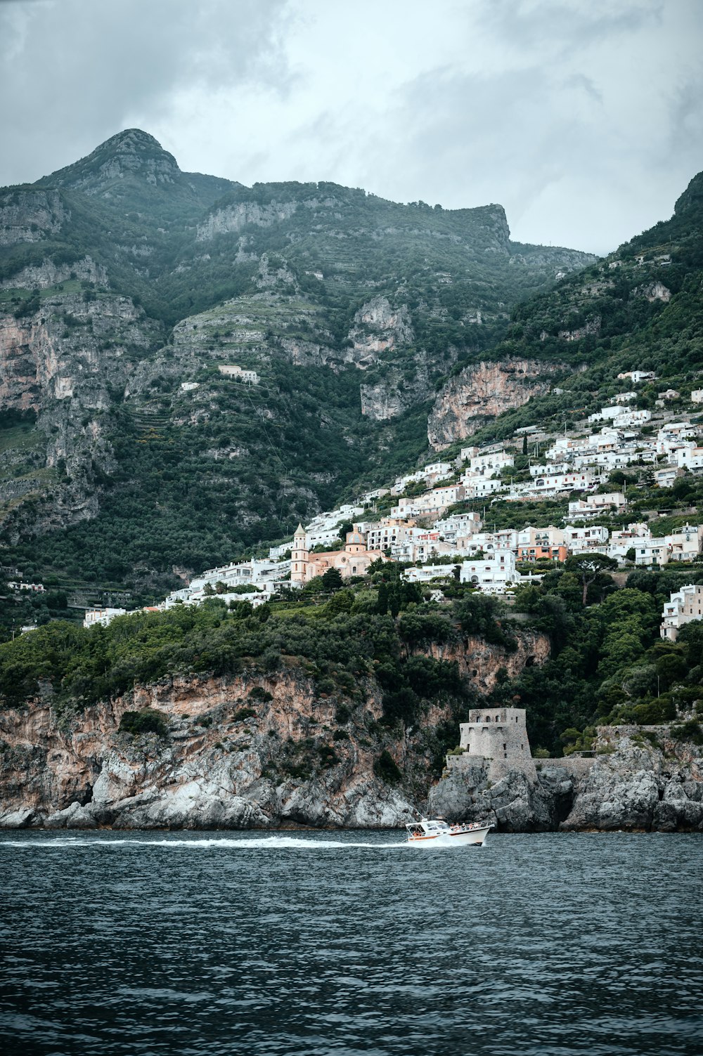 a boat is in the water near a mountain