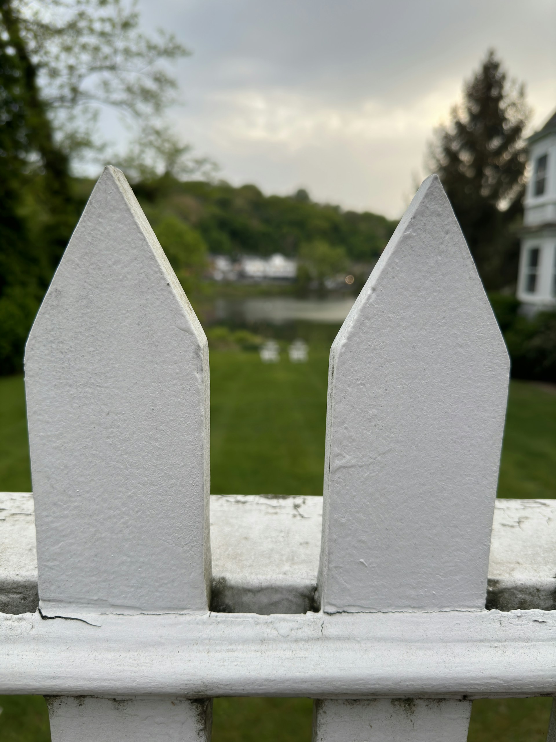 A panoramic view of a freshly installed white picket fence lining a charming home in Georgina.