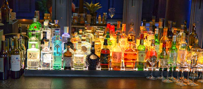 Bottles of whisky, gin, vodka, and cachaça arranged elegantly on a bar counter
