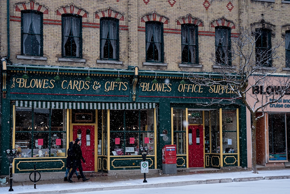a woman walking past a store front on a snowy day