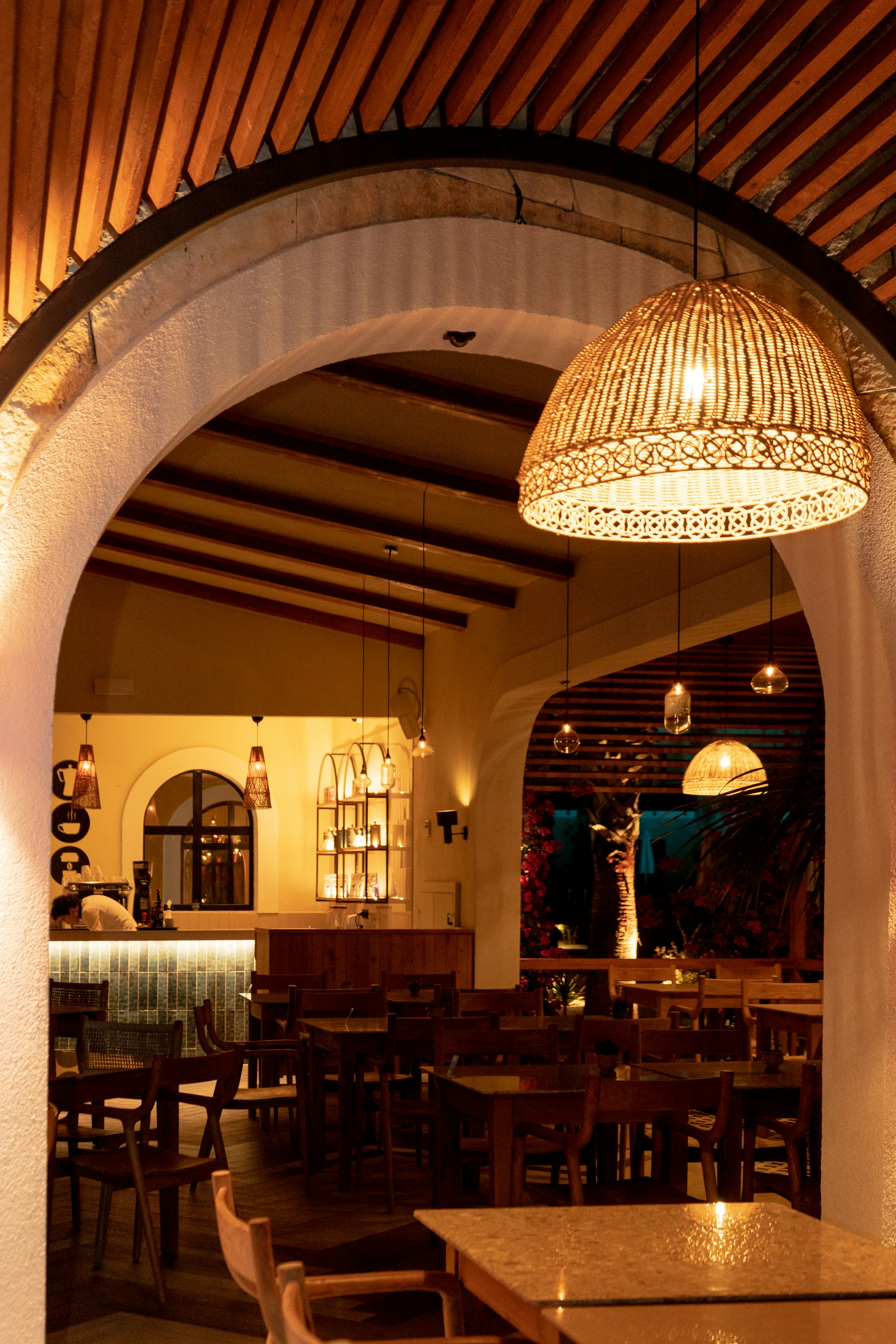Cozy interior of Restaurante Valdeherrera with warm lighting and rustic wooden tables set for a weekend event.