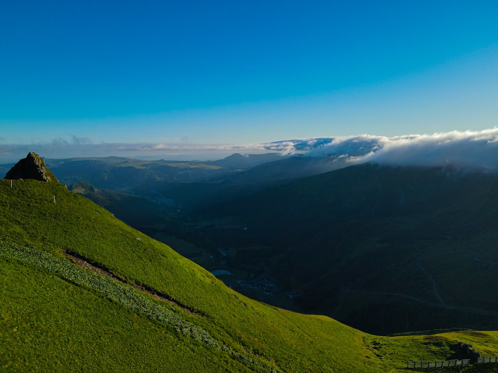 a grassy hill with a mountain in the background