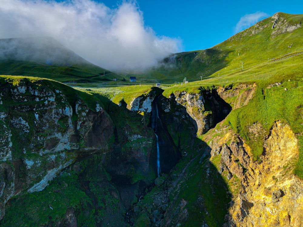 a waterfall in the middle of a green valley