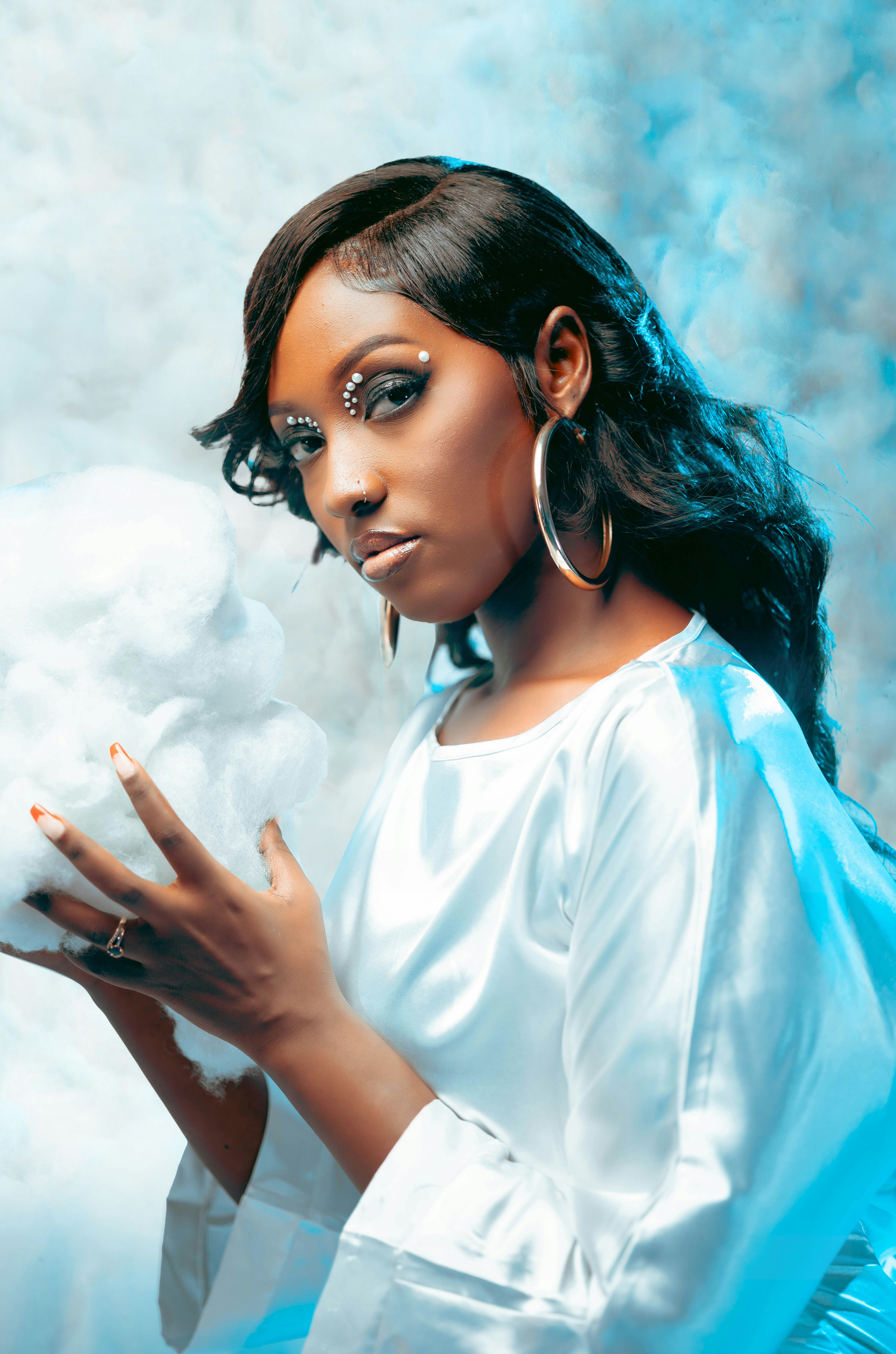 a woman in a white dress holding a cotton ball