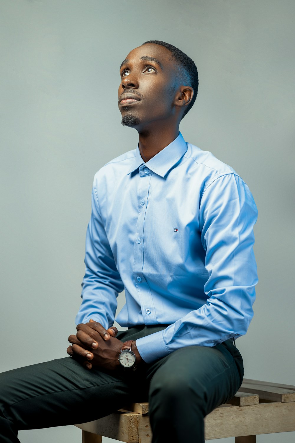 a man sitting on top of a wooden bench