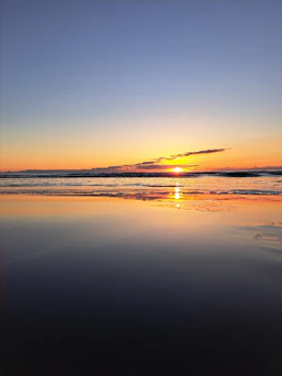 A serene sunset over calm ocean waters, reflecting a peaceful moment of contemplation.