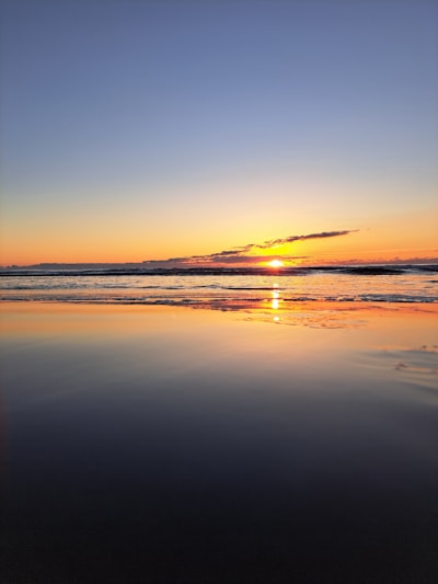 A serene sunset over a calm ocean, evoking travel dreams.