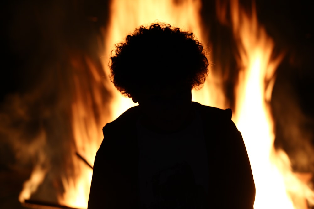 a person standing in front of a fire