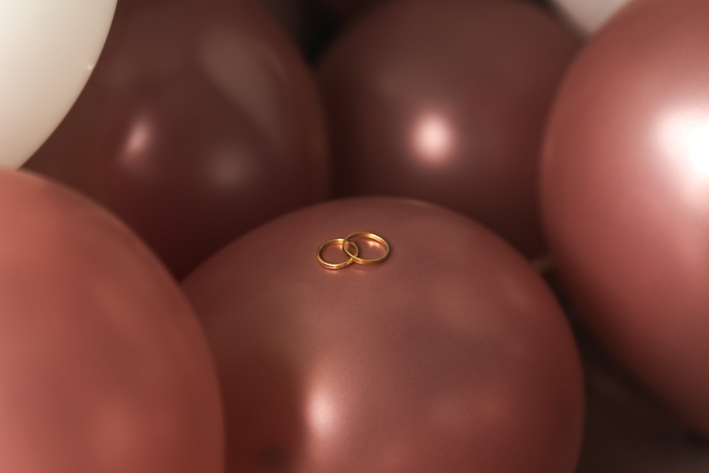 um par de alianças de casamento sentado em cima de um monte de balões